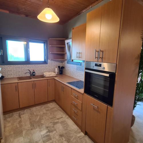 a kitchen with wooden cabinets and a stove top oven at Pure Blue House in Athanion