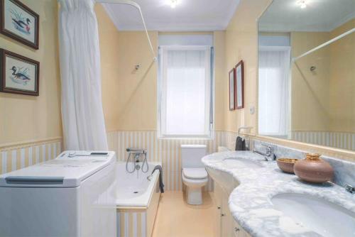 La salle de bains est pourvue de 2 lavabos, de toilettes et d'un miroir. dans l'établissement Apartamento Miramar, à Fontarrabie