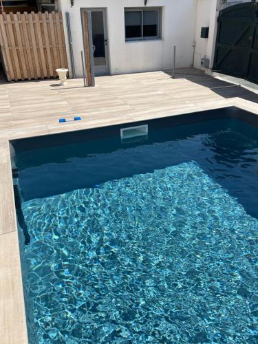 - une piscine d'eau bleue dans l'arrière-cour dans l'établissement Studio La Rochelle - Rompsay, à Périgny