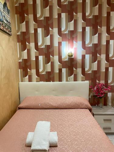 a bedroom with a pink bed with two towels on it at Mille Guest HOUSE in Rome