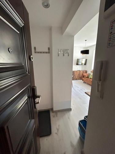Apartament Różany في كارباش: ممر مع باب وغرفة معيشة