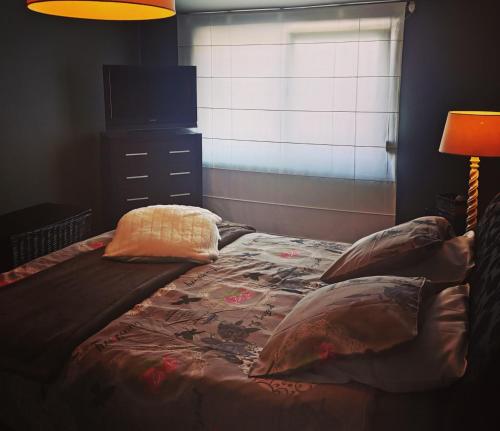 a bedroom with a bed with pillows and a television at La Constance in Chièvres
