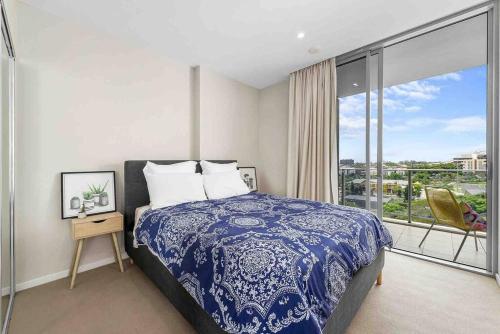 a bedroom with a blue and white bed and a balcony at The Fijian Hospitality in Brisbane
