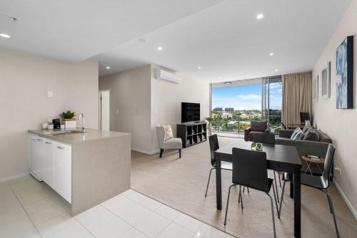 a kitchen and living room with a table and chairs at The Fijian Hospitality in Brisbane