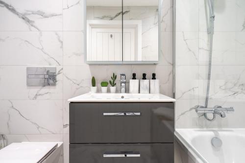 a white bathroom with a sink and a mirror at Hemel Apartments- Riverside Retreat in Hemel Hempstead