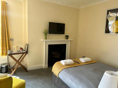 1 dormitorio con 1 cama y chimenea con TV en Bay Horse, en York
