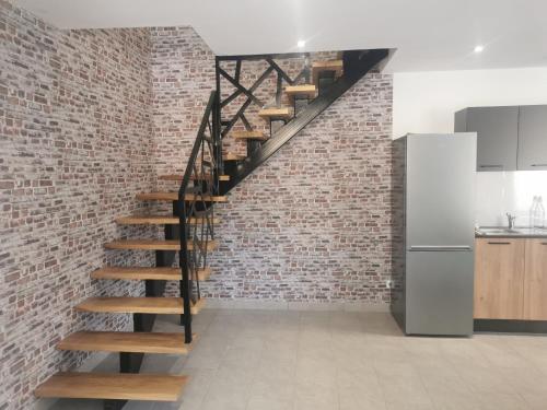 pared de ladrillo con escalera de caracol en la cocina en Maison mitoyenne au cœur du Pays Basque en Saint-Esteben