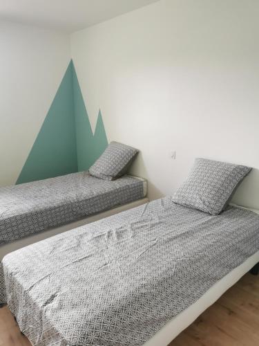 - 2 lits jumeaux dans une chambre avec une fresque murale de montagne dans l'établissement Maison mitoyenne au cœur du Pays Basque, à Saint-Esteben