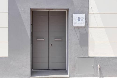 a door to a building with a sign on it at Domu Qirat - Authentic Rooms & Terraces in Tortolì