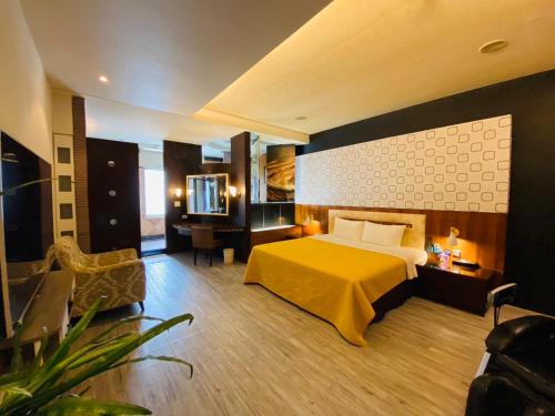 um quarto de hotel com uma cama e uma televisão em Holland Hill Motel em Tainan
