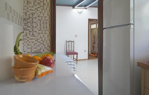 VENI Olive House في كالاماتا: غرفة بها سرير مع وعاء من الفواكه عليها