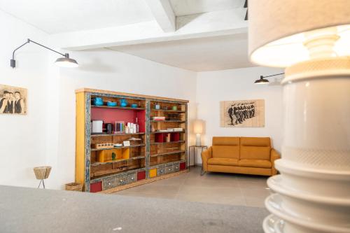 a living room with a couch and a book shelf at Domu Qirat - Authentic Rooms & Terraces in Tortolì