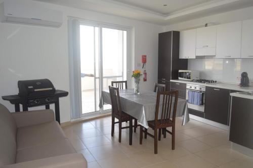 a kitchen and dining room with a table and chairs at White Pearl Apart 5 in Marsaxlokk