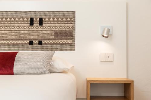 a bedroom with a bed with a picture on the wall at Domu Qirat - Authentic Rooms & Terraces in Tortolì