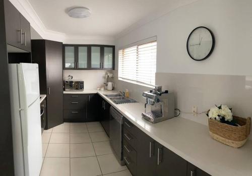 a kitchen with a counter and a sink and a mirror at Callie Beach Escape - Beachside View, Family Friendly, Walk Everywhere in Caloundra