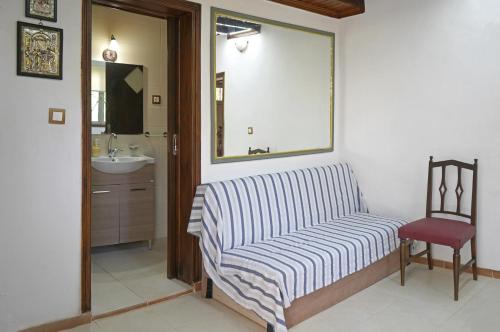 a living room with a striped couch and a chair at VENI Olive House in Kalamata