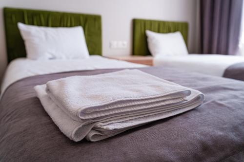 a pile of towels sitting on top of a bed at BnB Hotel Shymkent in Shymkent
