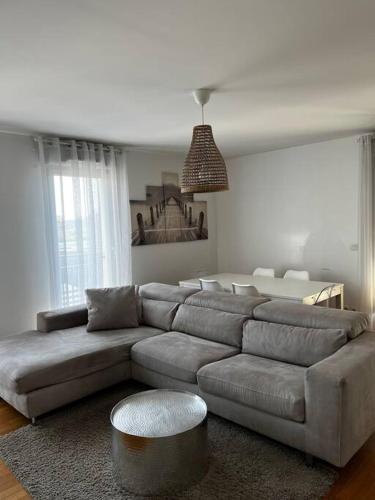 uma sala de estar com um sofá e uma mesa em Grand T2 La Plaine Saint Denis em Saint-Denis