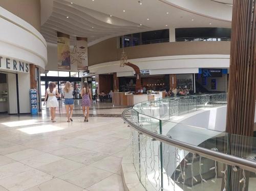 a mall with people walking through a shopping mall at Urban Retreat with a View in Windhoek