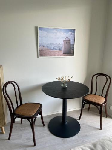 a table and two chairs in a room with a table at Uusi laadukas yksiö Hangon keskustassa in Hanko