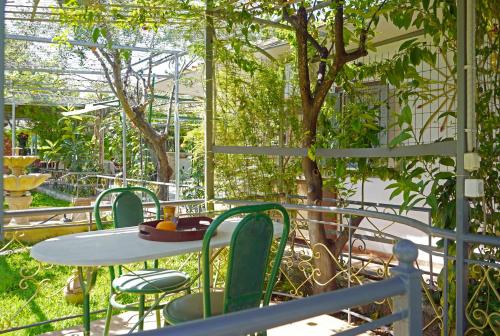 a table and chairs in a garden with a tree at VENI Olive House in Kalamata