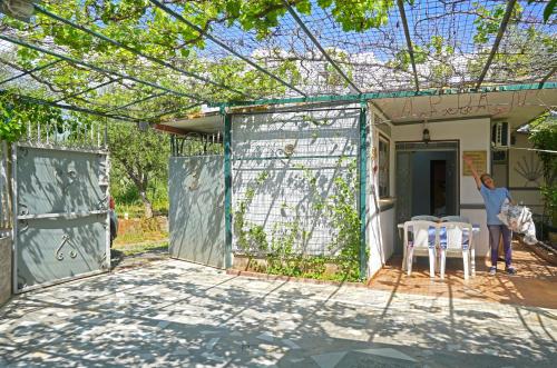a woman standing outside of a house with a pergola at VENI Olive House in Kalamata