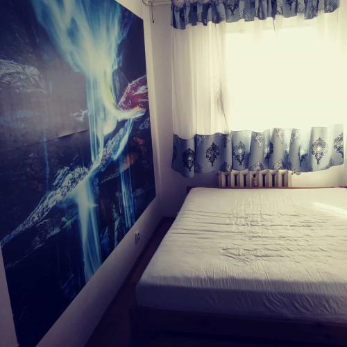 a bed in a room with a window and a poster at Vip apart in Gorlice