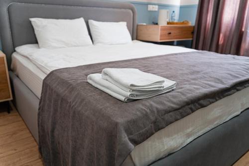 a bed with two towels sitting on top of it at BnB Hotel Shymkent in Shymkent