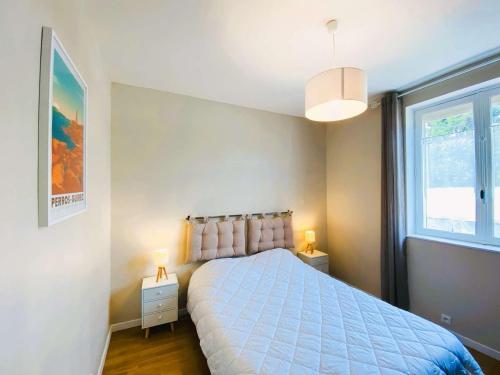 une chambre avec un lit bleu et une fenêtre dans l'établissement Maison 3 étoiles avec jardin clos, à 800 m de la plage, proche port de Saint-Sauveur, Île-Grande - FR-1-542-22, à Kerjagu