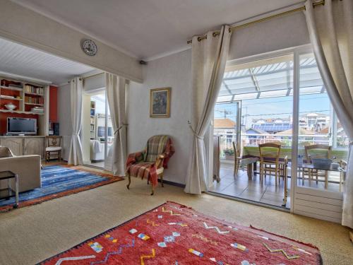 - un salon avec une porte coulissante en verre et une salle à manger dans l'établissement Appartement T3 avec Garage, Balcon et Véranda – Centre d'Arcachon, à 300m de la Plage - FR-1-433-47, à Arcachon