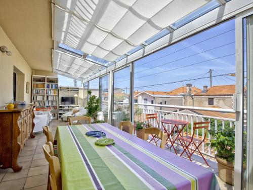 une véranda avec une table et une grande fenêtre dans l'établissement Appartement T3 avec Garage, Balcon et Véranda – Centre d'Arcachon, à 300m de la Plage - FR-1-433-47, à Arcachon