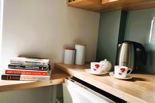 a kitchen counter with two coffee cups and books at Taboo by Housine in Zator