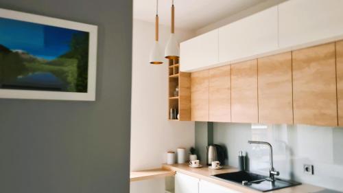 a kitchen with white cabinets and a sink at Taboo by Housine in Zator