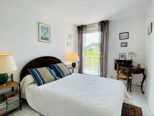 une chambre avec un lit, un bureau et une fenêtre dans l'établissement ARCACHON - Appartement 3 pièces avec terrasses et parking à 300m de la plage - FR-1-433-53, à Arcachon