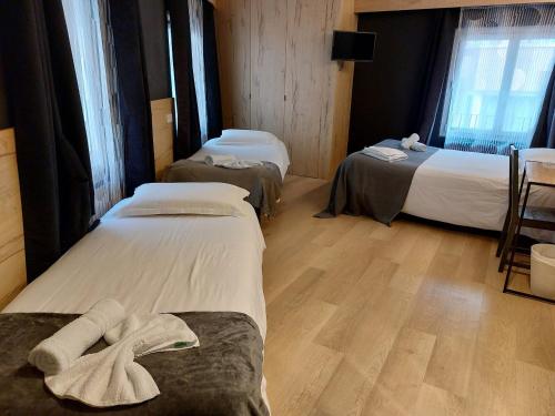 a room with two beds with towels on them at Hotel Mirtil in Pas de la Casa