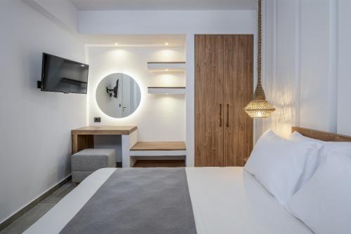 a bedroom with a bed and a clock on the wall at Gaia Village in Tigaki