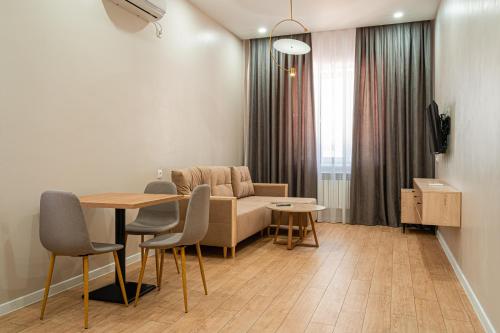 a living room with a table and a couch at BnB Hotel Shymkent in Shymkent