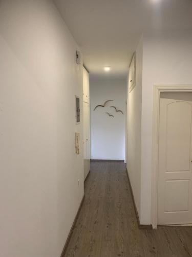 a hallway with a white wall and a door at MV central in Rhodes Town
