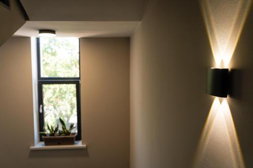 a room with a light on the wall and a window at BnB Hotel Shymkent in Shymkent