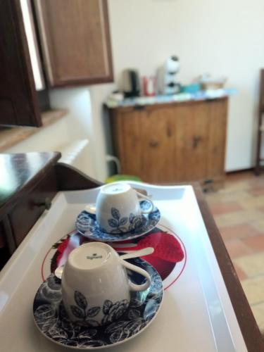two cups and saucers on a table in a kitchen at All'Ombra di San Damiano in Assisi