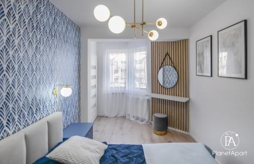 a bedroom with a bed and a blue patterned wall at PlanetAparts in Darłowo