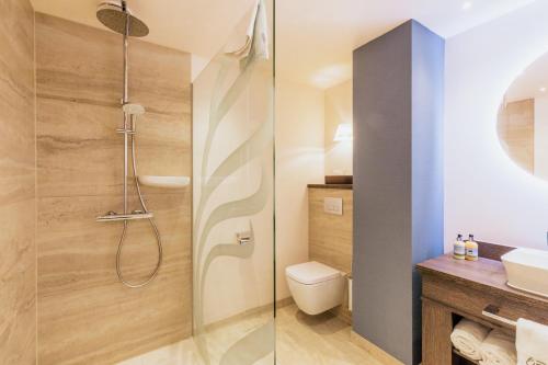 a bathroom with a shower and a toilet at Grand Hotel Opduin in De Koog
