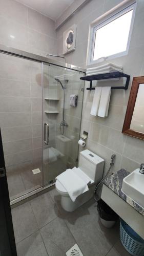 a bathroom with a shower and a toilet and a sink at Comfort Inn in Kampong Selayun