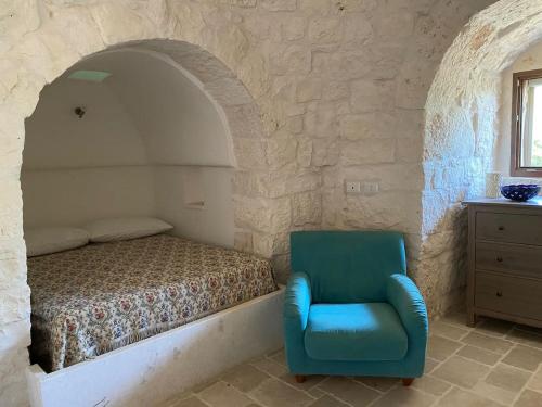 Trullo Raimondo في مارتينا فرانكا: غرفة نوم بسرير وكرسي ازرق