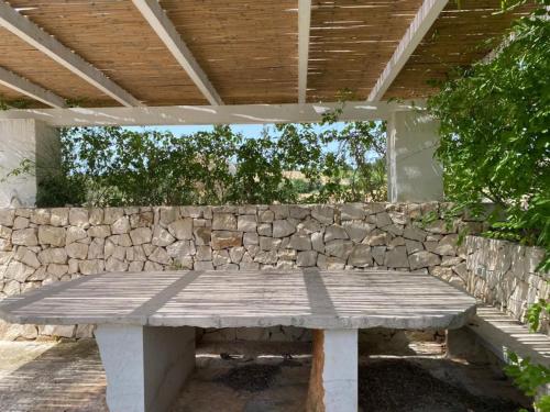 a stone wall with a picnic table in front at Trullo Raimondo in Martina Franca