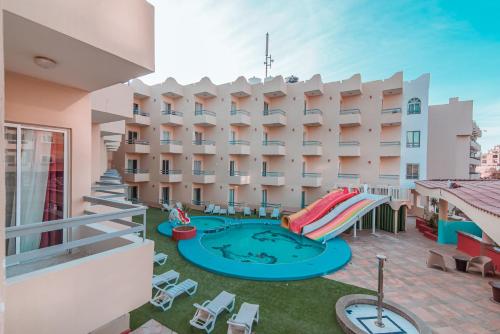 een patio met een zwembad en een gebouw bij Dexon Roma Hotel in Hurghada