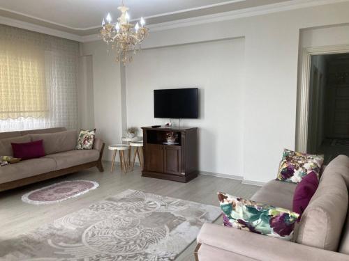 a living room with a couch and a flat screen tv at Günlük haftalık aylık kiralik eşyalı daire Trabzon Boztepe in Degirmen
