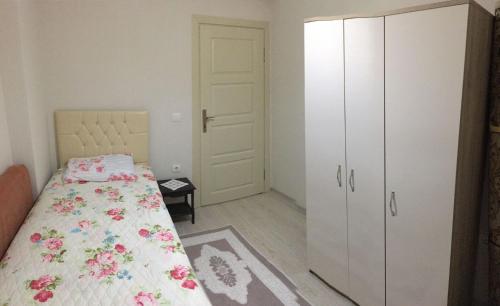a bedroom with a bed and a white cabinet at Günlük haftalık aylık kiralik eşyalı daire Trabzon Boztepe in Degirmen