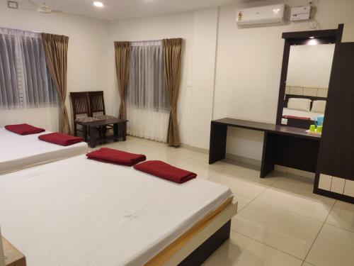 a room with two beds and a desk and a mirror at SDK RESIDENCY in Shravanabelagola