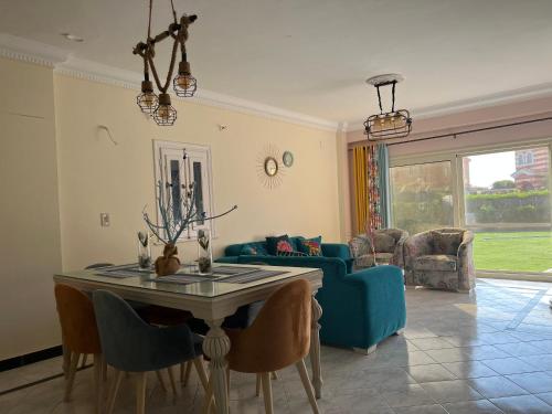 ein Wohnzimmer mit einem Tisch und einem blauen Sofa in der Unterkunft Caribiano villa-3 in Dawwār Ḩalīs